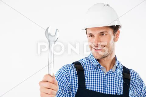 Smiling male handsome builder holding wrench Stock Photos