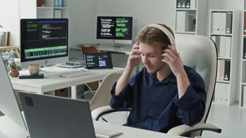 Smiling Male IT Engineer Taking off Headphones while Working at Office Desk Stock Footage 330125828