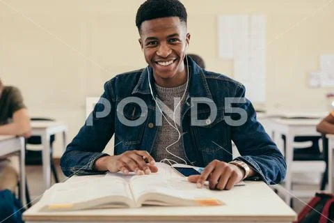 Smiling male student in university classroom Stock Photos