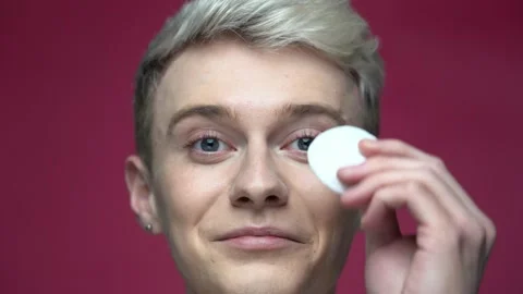 Smiling male using cotton pad remove makeup from face. Cleaning face concept Stock-Footage 155462305