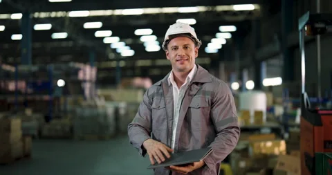 Smiling male warehouse engineer in gray uniform wearing safety helmet givin.. Stock Footage 307014735