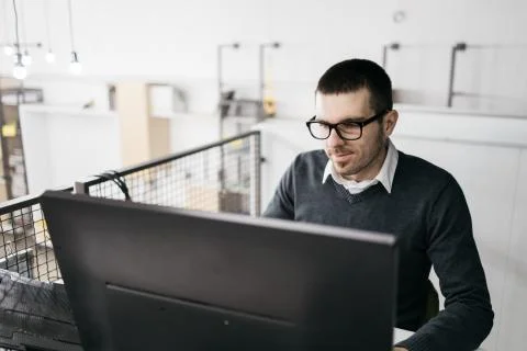 Smiling male worker working on computer in office Stock Photos
