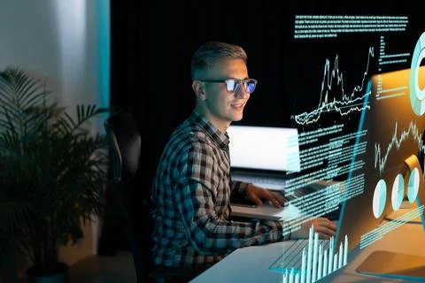 Smiling Man Analyzing Data on Computer Screen in Office Stock Photos