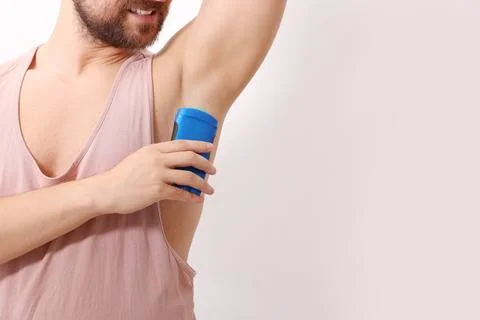 Smiling man applying solid deodorant on white background, closeup. Space fo.. 스톡 사진