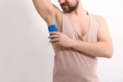 Smiling man applying solid deodorant on white background, closeup. Space fo.. Stock Photos
