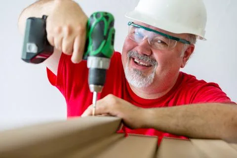 Smiling man assembling wood with drill-drive Stock Photos