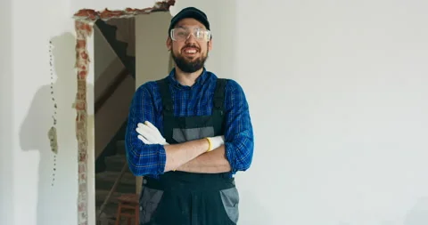Smiling man in baseball cap wearing protective suit and plaid shirt has goggles Stock Footage 219714035