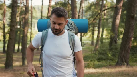 Smiling Man With Beard And Backpack In Forest Uses Phoneapp Icon With Online Stock Footage 125211877