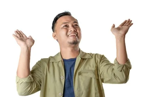 Smiling man in beige jacket points upward with enthusiasm showing confidence Stock Photos