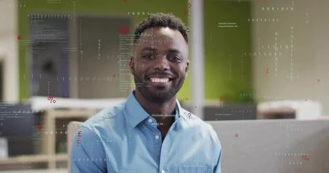 Smiling man in blue button-down shirt posing in open-plan office, with code Foto stock