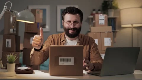 Smiling man with box looks at camera and shows thumb up. Happy regular customer Video stock 188744226