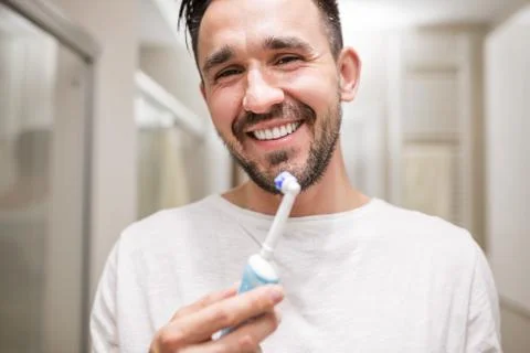 Smiling man brushing his teeth Stock Photos