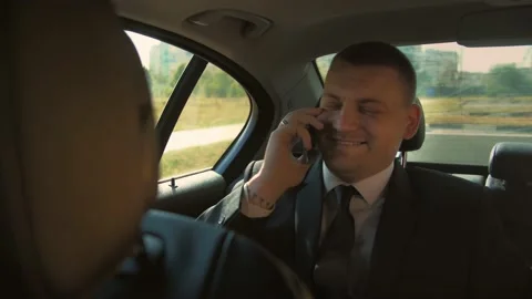 Smiling man in a business suit talking on mobile phone at car. Stock Footage 201086359