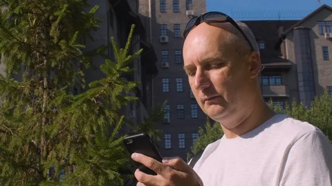 Smiling man calling and talking on phone while wearing sunglasses on sunny day Video stock 93264319