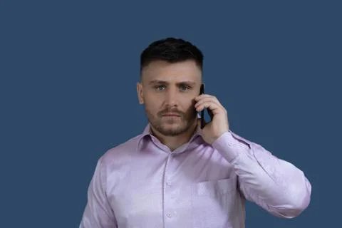 Smiling man calling on the phone.Man on a gray background. Stock Photos