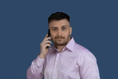 Smiling man calling on the phone.Man on a gray background. Stock Photos