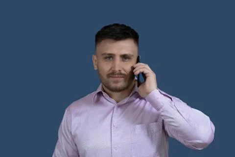 Smiling man calling on the phone.Man on a gray background. Stock Photos