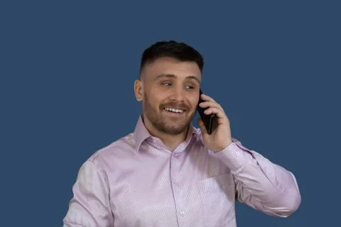 Smiling man calling on the phone.Man on a gray background. Stock Photos