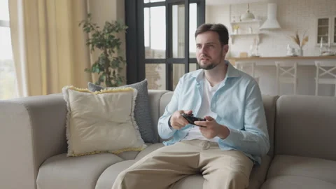 Smiling Man Celebrates Victory While Playing Video Game On Couch At Home Stock Footage 311259219