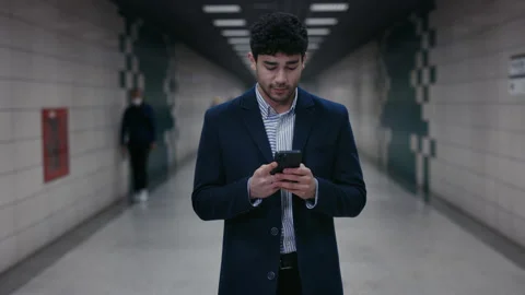Smiling man chatting online using mobile at metro station Stock Footage 153792921