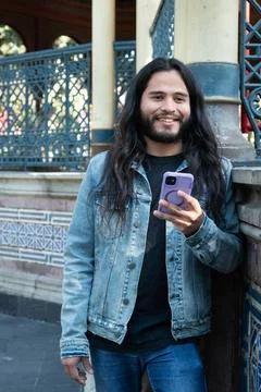 Smiling man communicating outdoors using smartphone technology Stock Photos