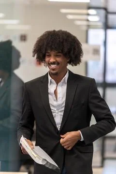 Smiling man with documents in a business setting. Fotos Stock