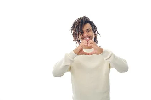 Smiling man doing a heart shape with hands while standing over an isolated Stock Photos