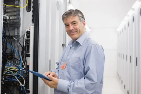 Smiling man doing maintenance on servers Stock Photos