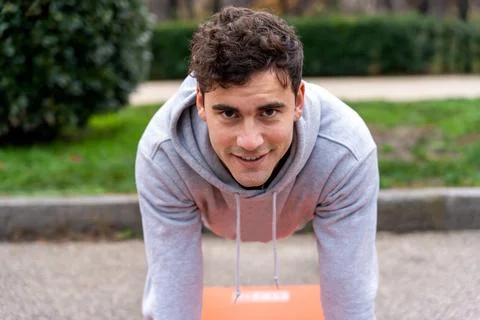 Smiling man doing plank in park Stock Photos