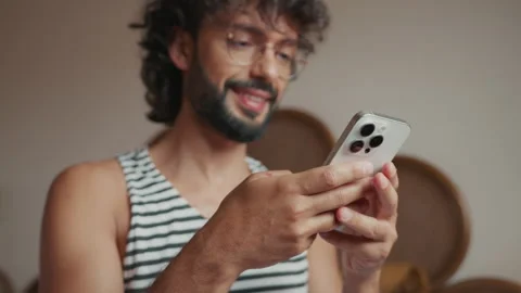 Smiling Man Engaged with His Smartphone At Home Stock Footage 334625166