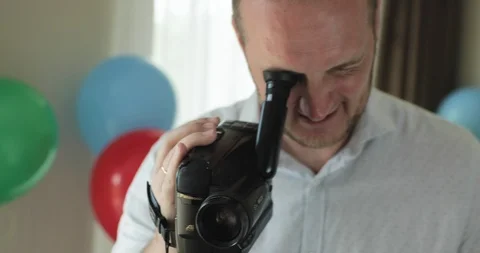 A smiling man in a festive cap is shooting something on camera Stock-Footage 122429257
