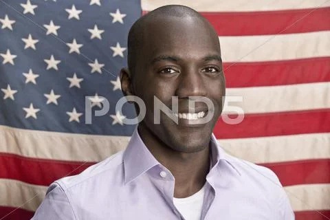 Smiling man in front of American flag Stock Photos