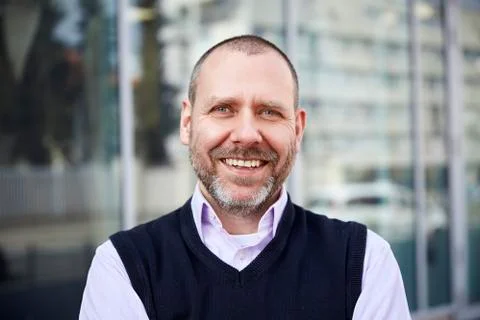 Smiling man in front of the building Photos