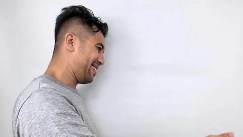 Smiling Man Gesturing and Presenting on a White Background. Stock Footage 315235863