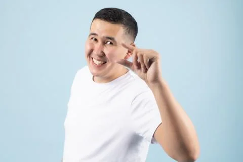 Smiling Man Gesturing Small Amount with Fingers Stock-Fotos