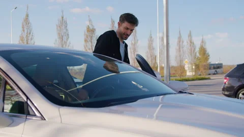 Smiling man gets in car-sharing vehicle to begin journey Stock Footage 300475553