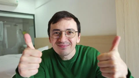 Smiling man with glasses giving thumbs up Video stock 337366697