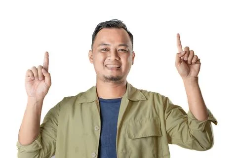 Smiling man in green jacket points upwards showing enthusiasm Foto stock