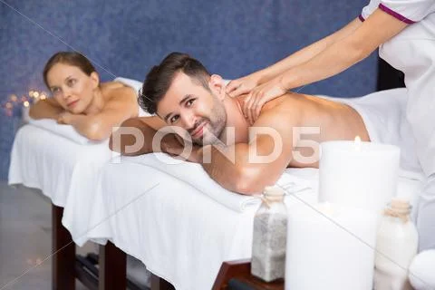 Smiling man having massage and woman in spa center Stock Photos