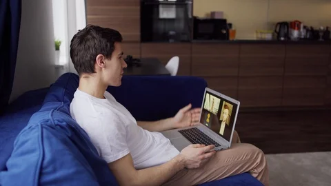 Smiling man having video call with colleagues Stock Footage 128758424