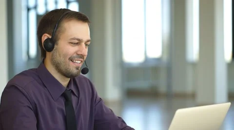 A smiling man with headset working as a call center operator Stock Footage 67660453