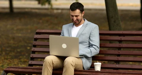 Smiling  man holding portable computer on knees and working out of office. Video stock 140946900