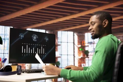 Smiling man in home office using financial application UI on PC screen Stock Photos