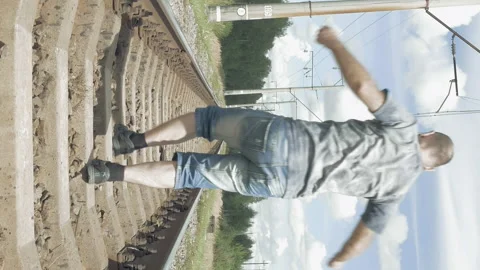 Smiling man jumping dancing on the railway tracks Stock Footage 90422495