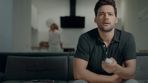 Smiling man looking for tv program at kitchen. Relaxed man checking tv channels Video stock 113115367