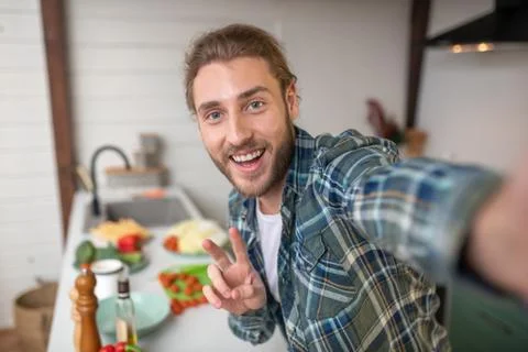 Smiling man making selfie on his kitchen 스톡 사진