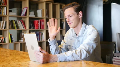 Smiling man making video call with tablet pc computer Video stock 64703111