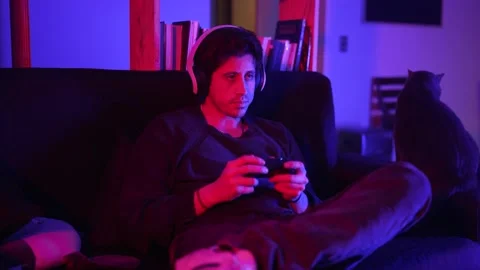 A smiling man in a medium shot plays video games in his apartment Stock Footage 199128838