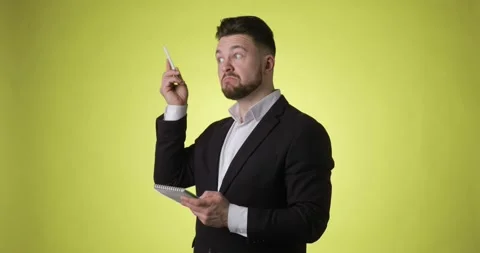 Smiling man in office suit thinks and takes notes in paper notebook having idea. Stock Footage 149067375