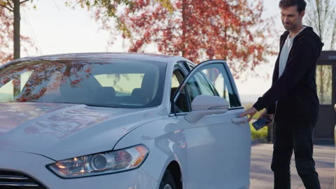Smiling man opens car-sharing auto using mobile application Stock Footage 300473706